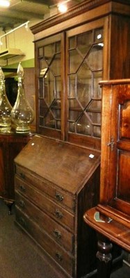 Lot 618 - An oak bureau with later glazed bookcase top