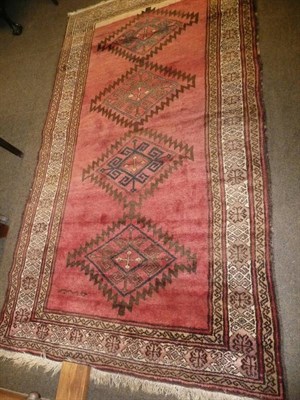 Lot 659 - A rug with four lozenge design on a russet ground