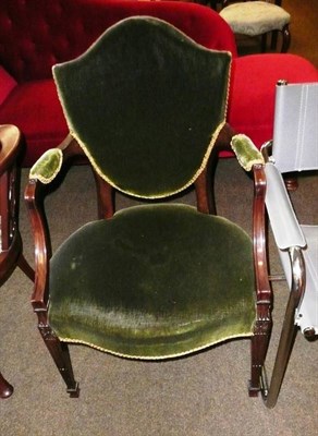 Lot 673 - A green velvet upholstered shield back open armchair