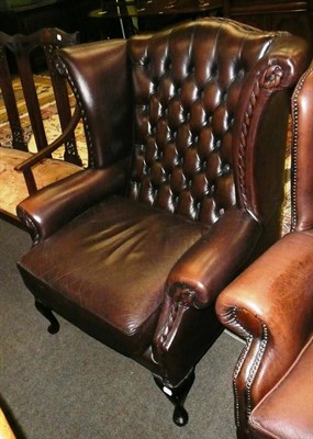 Lot 690 - A brown leatherette button back wing armchair