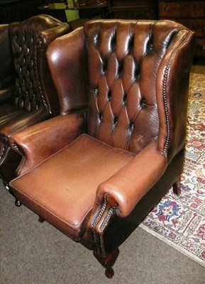 Lot 691 - Brown leather style wing armchair