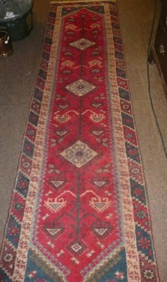 Lot 732 - A long runner with red ground and multiple borders, 291cm by 73cm