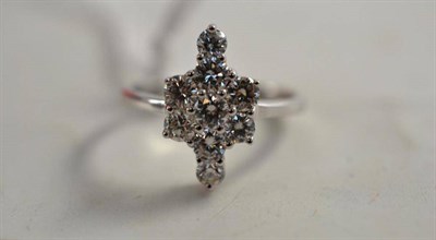 Lot 76 - A diamond ring, nine round brilliant cut diamonds arranged as a stylised cross, in white claw...