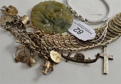 Lot 82 - A jade pendant, a white metal bangle inset with stones, silver charm bracelet, crucifix, a...