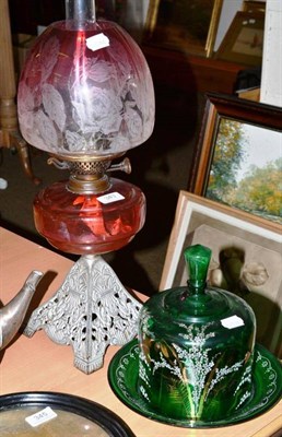 Lot 343 - Cranberry glass oil lamp with shade and green glass cheese dome and cover with painted...