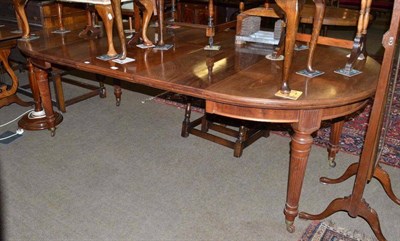 Lot 526 - A walnut extending dining table on reeded legs