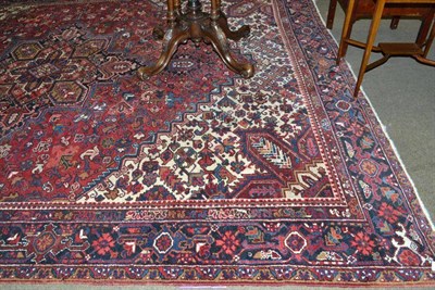 Lot 537 - Heriz carpet Persian Azerbaijan, the claret field of stylised vines around an indigo medallion...