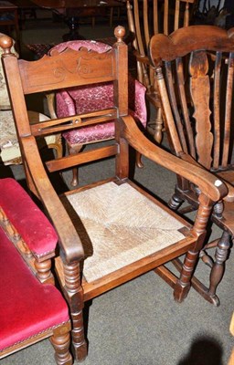 Lot 560 - An oak ladder back open armchair with rush seat