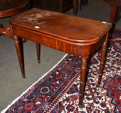 Lot 584 - A 19th century mahogany fold-over tea table with turned legs