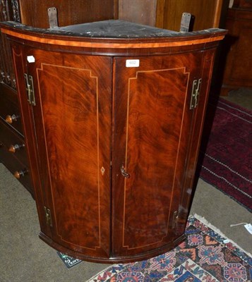 Lot 602 - A Georgian mahogany inlaid bow front corner cabinet