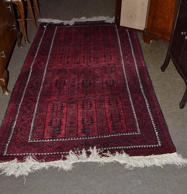 Lot 603 - A Balouch rug West Afghanistan, the compartmentalised field of stylised plants enclosed by...