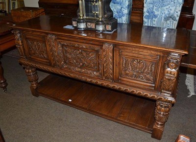 Lot 620 - A carved oak two tier serving table