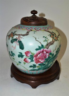Lot 5 - A 19th century Chinese famille rose ginger jar with a carved wooden lid, on stand