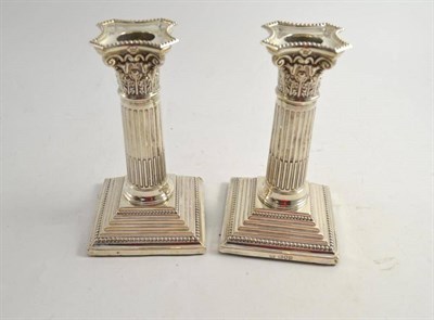 Lot 243 - A pair of silver candlesticks with fluted columns and stepped bases