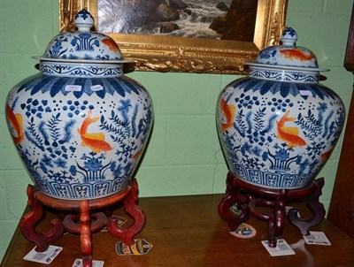 Lot 351 - A large pair of Oriental lidded jars on wooden stands