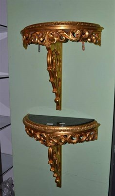 Lot 420 - A pair of gilt wall brackets of demi-lune form with green marble tops