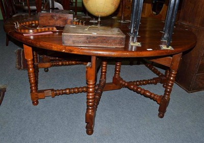 Lot 516 - Large modern oak oval drop leaf table on turned supports