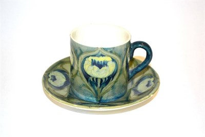 Lot 701 - A William Moorcroft Poppy Pattern Cup and Saucer, on a green ground, impressed factory marks...