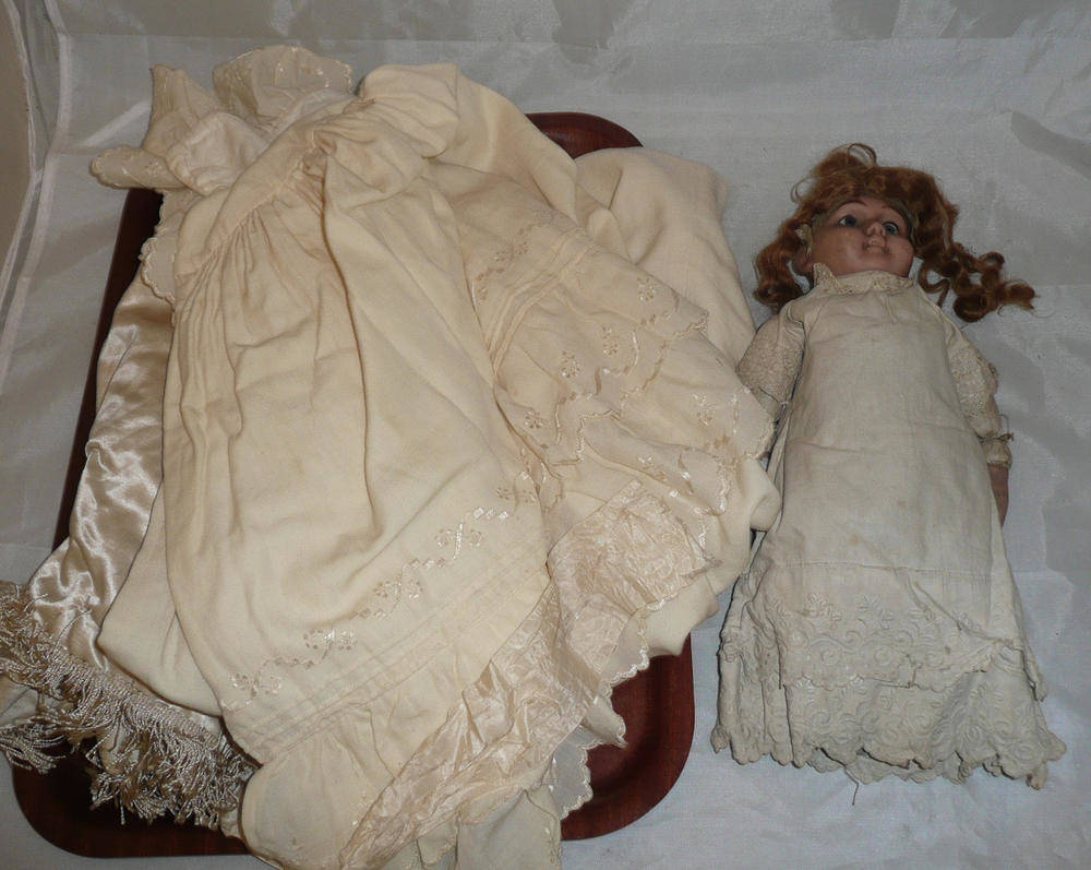 Lot 216 - A bisque headed doll and a cream wool embroidered cape