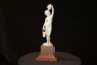 Lot 792 - An Art Deco Carved Ivory Nude Figure, modelled as a Roman water carrier, with a bunch of fruit held