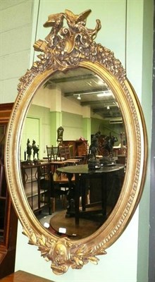 Lot 470 - A large gilt-framed oval mirror