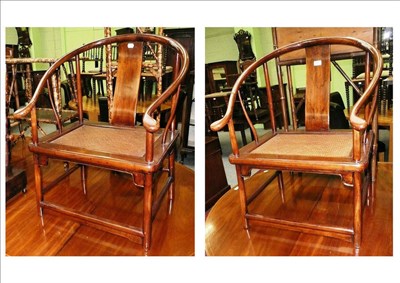 Lot 498 - A pair of Chinese stained hardwood horseshoe armchairs, 20th century, with U shaped top rails,...