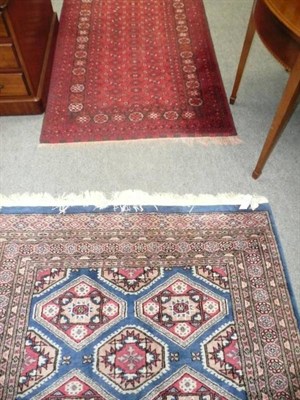 Lot 499 - Two Eastern rugs, in crimson and in blue and pink