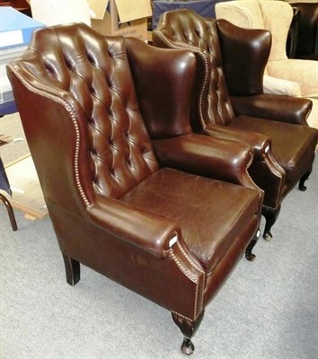 Lot 518 - A pair of brown leather button-back wing chairs