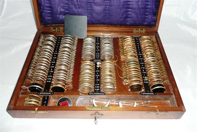 Lot 1042 - A Walnut Cased Set of Opticians Test Lenses, contains brass and nickel framed lenses and nickel...