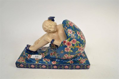 Lot 53 - Pottery figure of a young lady seated in an egg