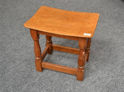 Lot 856 - A Robert  "Mouseman " Thompson Oak Dish Top Stool, the adzed top on four octagonal legs joined...