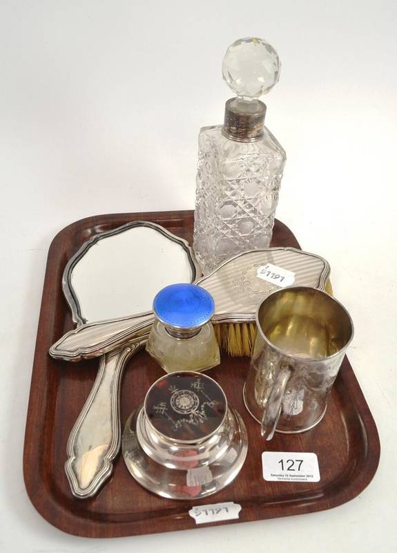 Lot 127 - A silver mug, a silver mounted dressing mirror and brush, silver mounted inkwell, glass bottle...