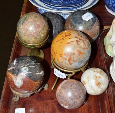 Lot 213 - Seven marble balls and three brass stands