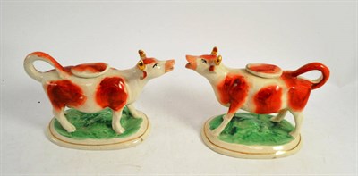 Lot 360 - Pair of cow creamers with lids