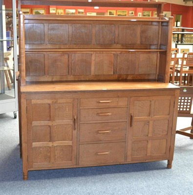 Lot 890 - A Yorkshire School 5' Panelled Oak Dresser, the plate rack with a shelf, the base with two cupboard