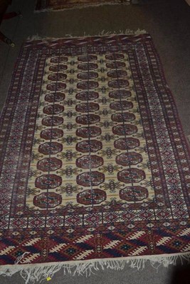 Lot 507 - A wool cream ground Eastern pattern rug with central lozenges