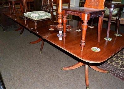 Lot 523 - A Georgian style triple pillar dining table