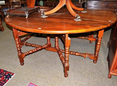 Lot 542 - Large modern oak oval drop leaf table on turned supports