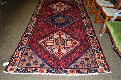 Lot 571 - Luri carpet West Persia, the tomato red field with three hooked medallions enclosed by ivory...