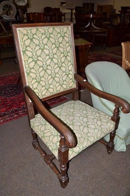 Lot 582 - A 17th century style carved oak open arm elbow chair with green damask upholstery