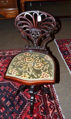 Lot 586 - A late Victorian mahogany revolving piano seat, late 19th century, the pierced fan shape back...