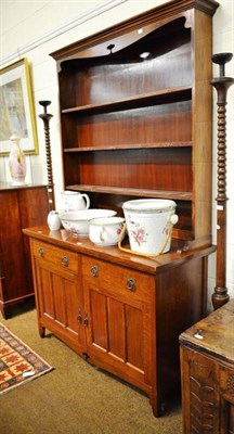 Lot 640 - An Arts & Crafts style oak dresser and rack