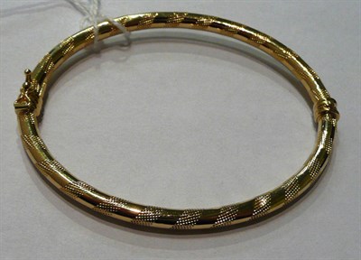 Lot 4 - A hollow granulated motif bangle, stamped '750'