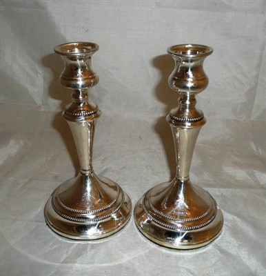 Lot 111 - Pair of silver loaded candlesticks with armorial crest