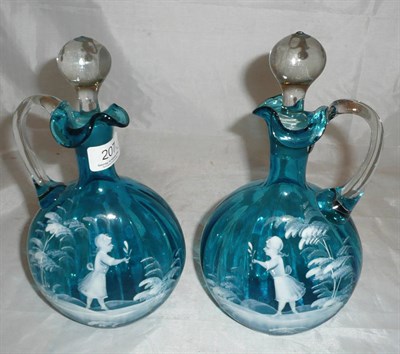 Lot 207 - A pair of blue glass ewers with Mary Gregory type decoration