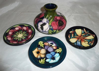 Lot 211 - A Moorcroft pottery vase decorated with flowers, three small dishes, and a Moorcroft book (5)