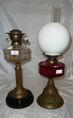 Lot 252 - A brass oil lamp with cranberry font and another