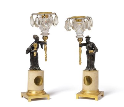 Lot 962 - A Pair of Regency Parcel Gilt Bronze Figural Candlesticks, the cut glass sconces hung with...