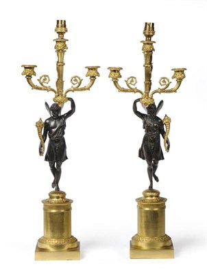 Lot 964 - A Pair of French Restauration Three-Light Figural Candelabra, with fruit and leaf sheathed...