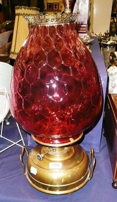 Lot 359 - Oil lamp with cranberry glass shade